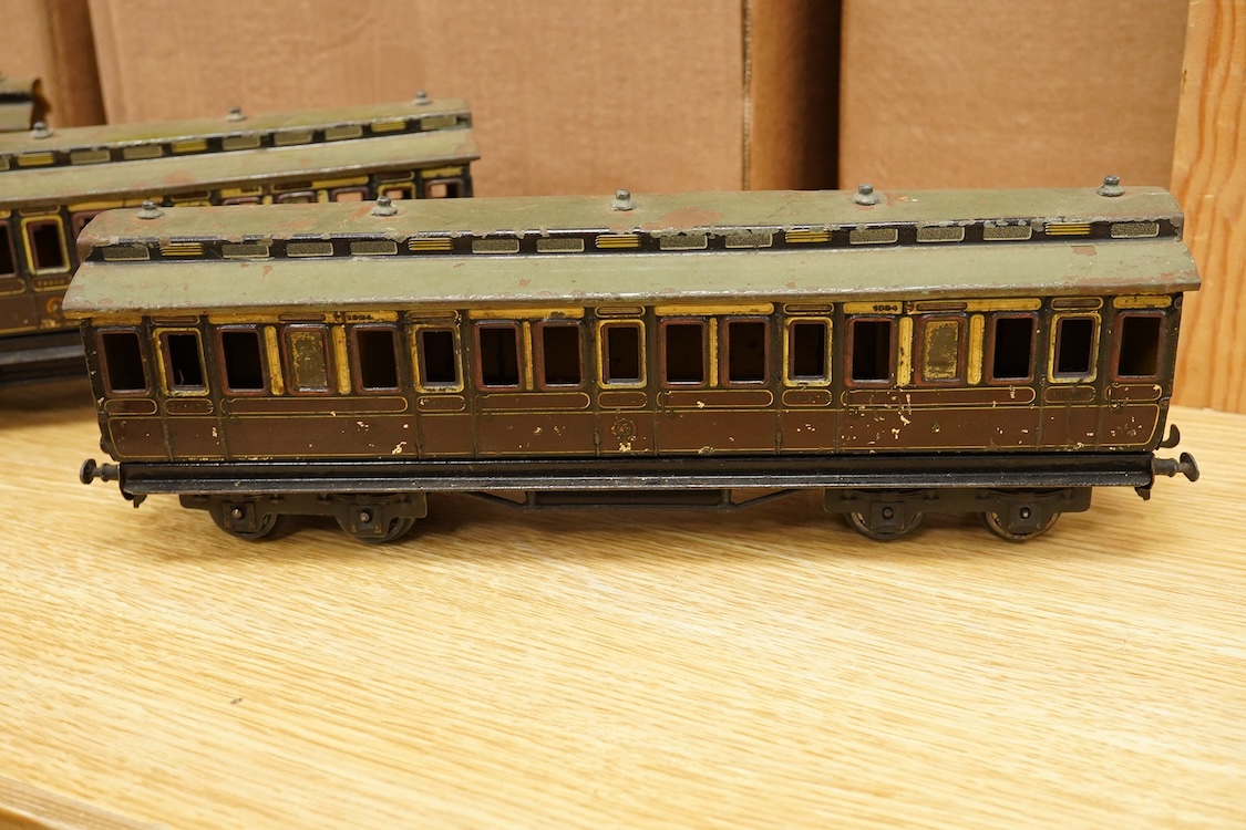 Three Carette for Bassett-Lowke 0 gauge tinplate GWR clerestory bogie coaches; two First Third Composite coaches, both 1324, and a full brake van, 1334, all in chocolate and cream livery